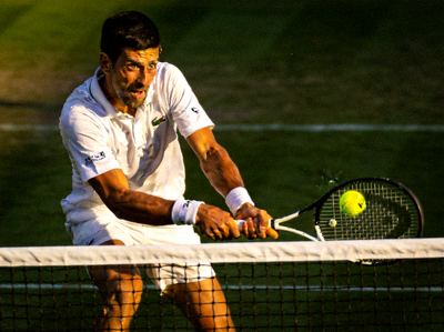 诺瓦克·德约科维奇在网球场上奋力击球的专注神情